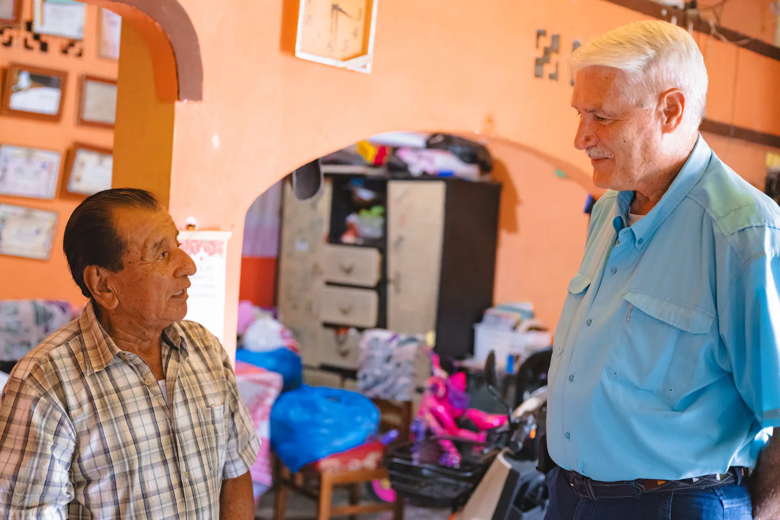 Russell listening to a pastor during a visit in his home in Ecuador.