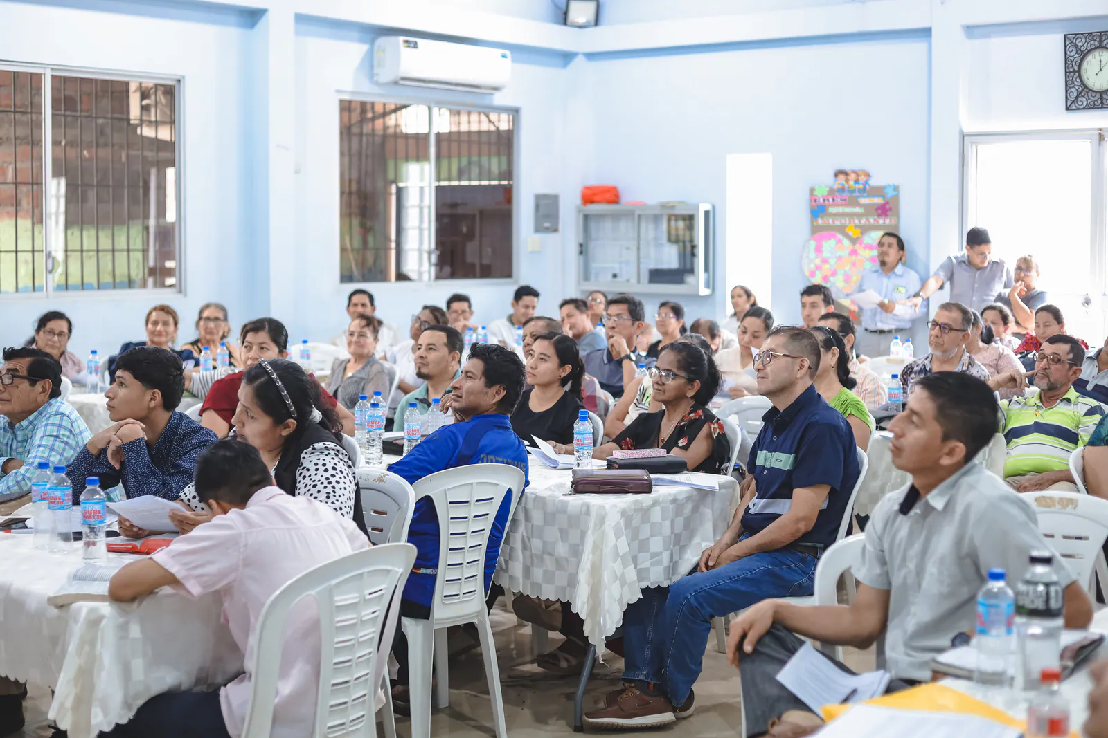 Pastors gathered for biblical training with Bibles and study materials on the tables.